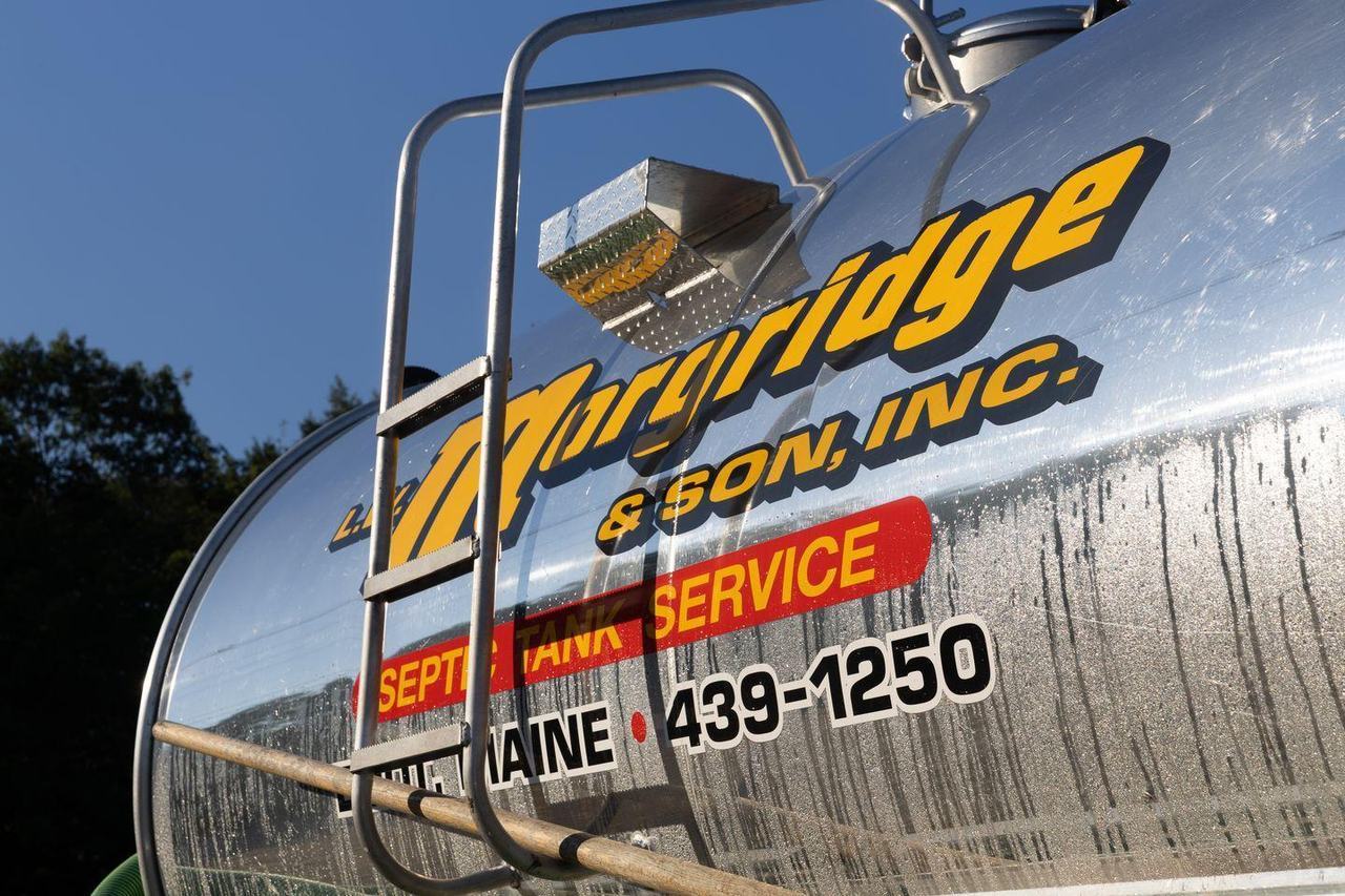 The polished tank of a Morgridge truck with the company name and phone number.