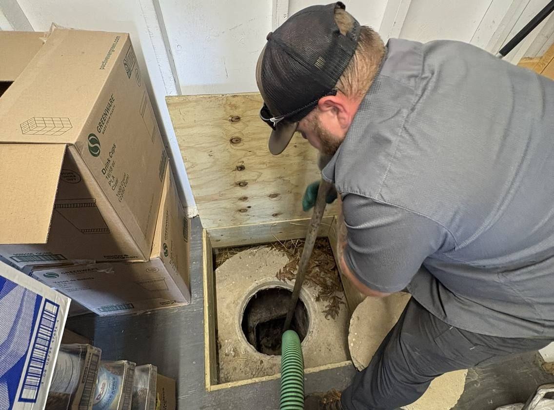 A grease trap opened at a commercial kitchen with the service hose run in.