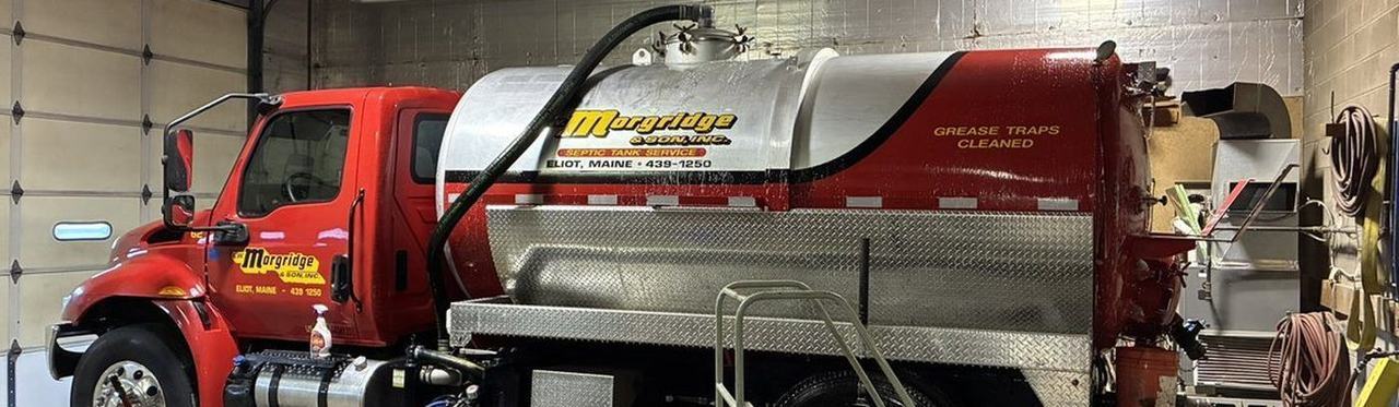 A grease trap opened at a commercial kitchen with the service hose run in.