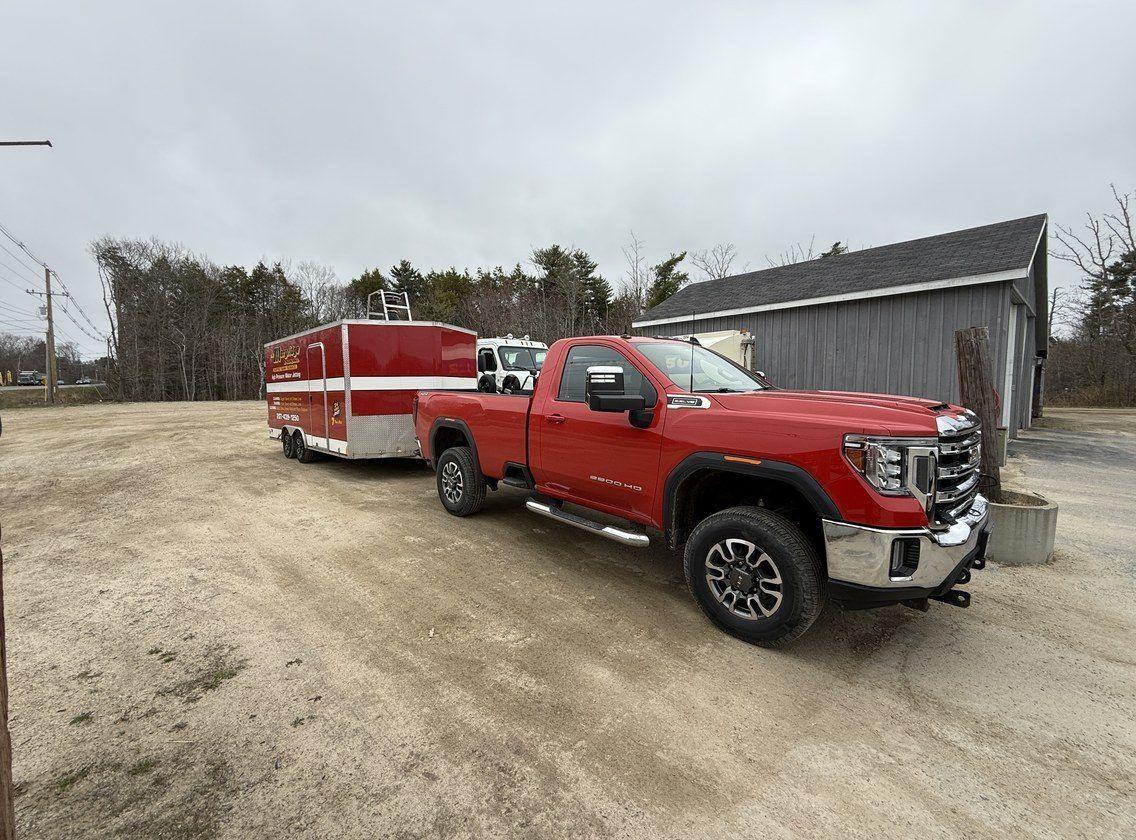 The jetter trailer rig hitched behind the service truck at a job site.