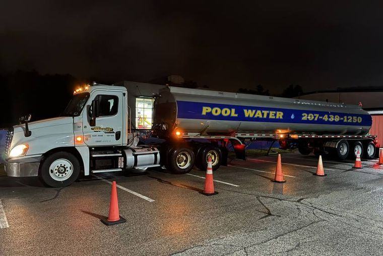 The delivery hose run from the tanker into the pool.