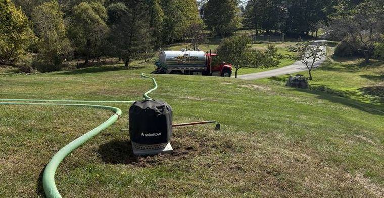 A riser and cover set at grade in a lawn after installation.