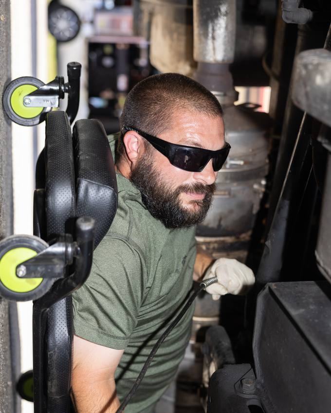 A mechanic servicing one of the trucks in the shop.